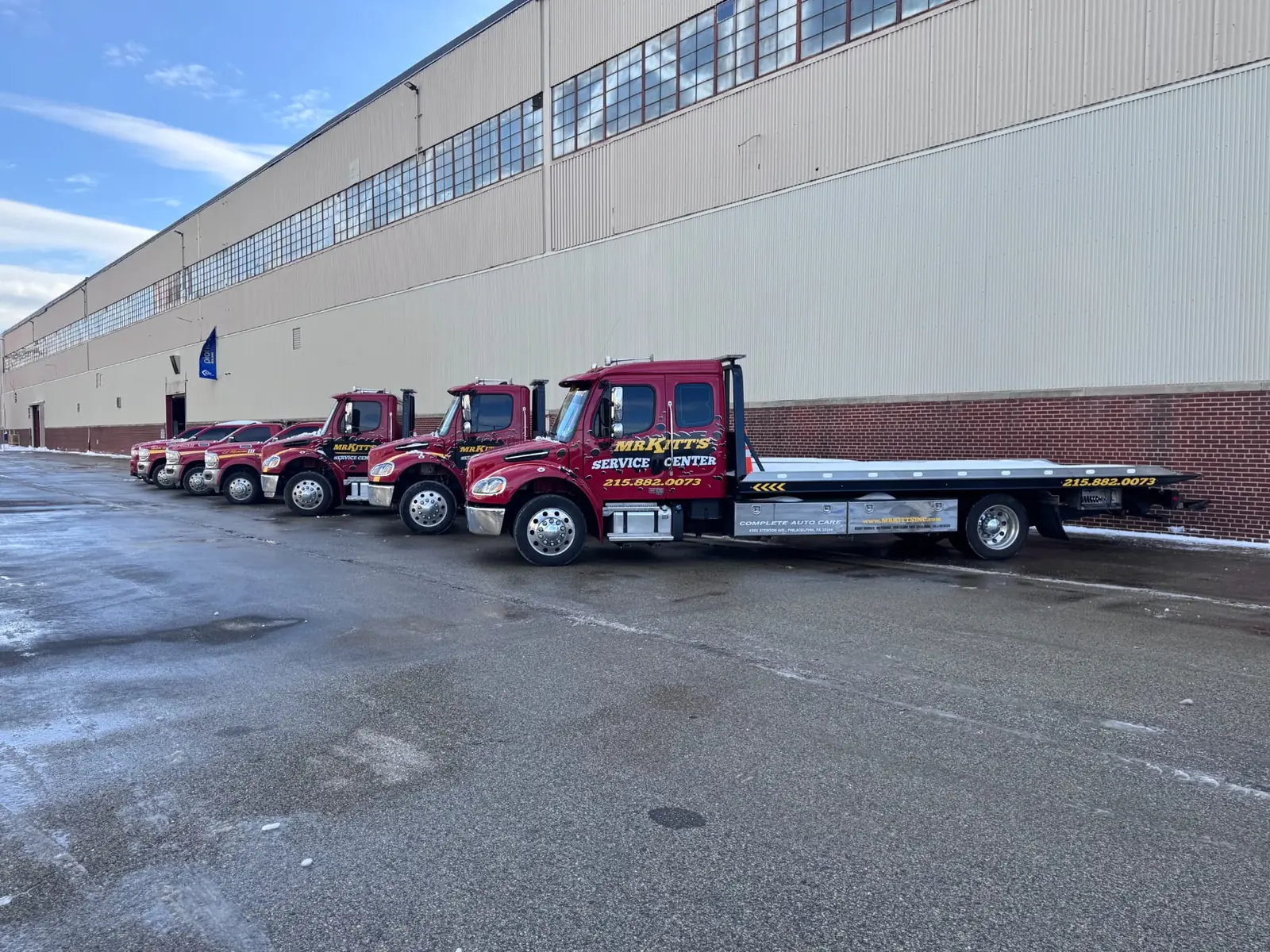 Six Mr. Kitt's tow trucks lined up at the yard