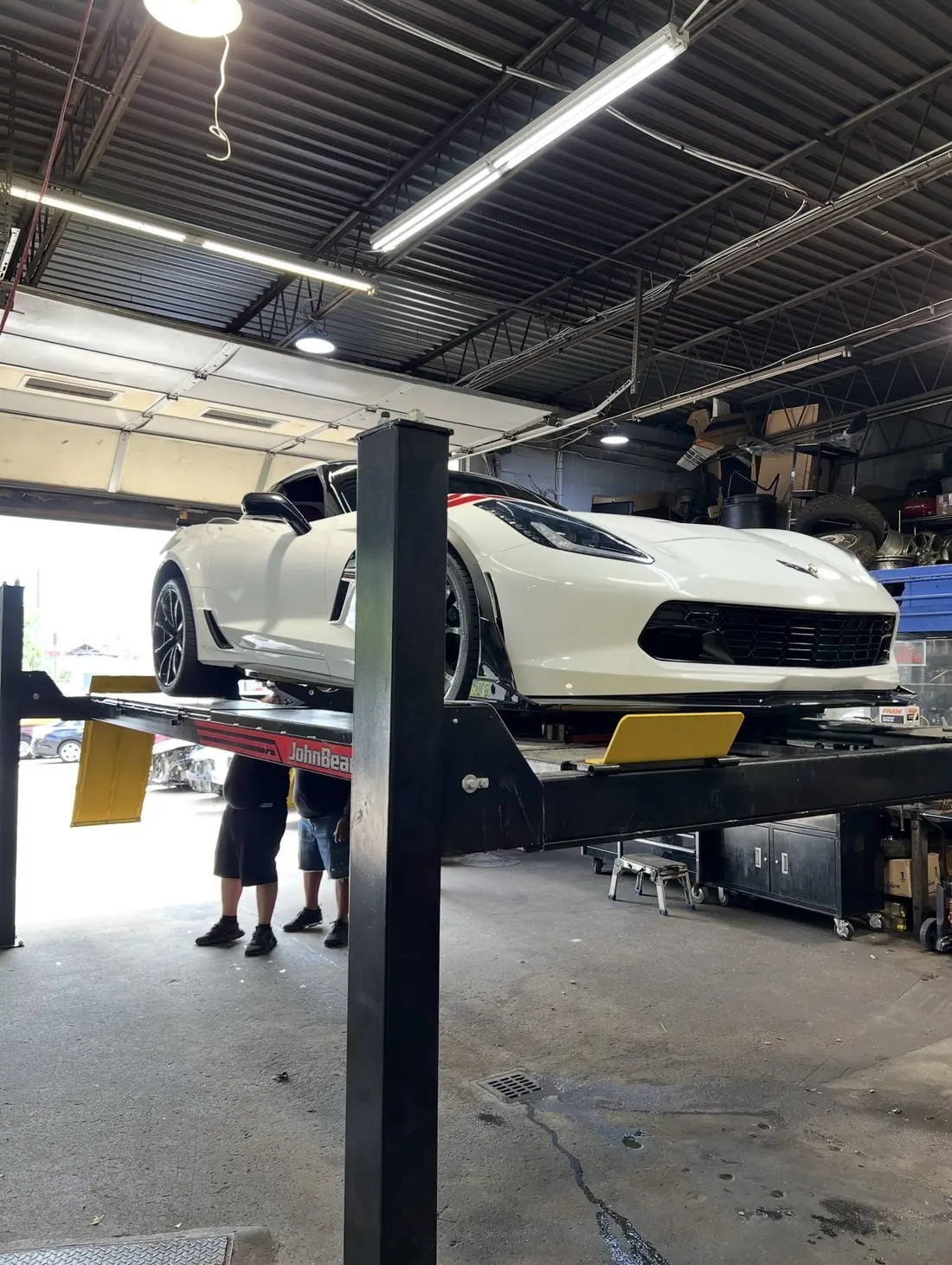 A Chevrolet Corvette raised on the four-post lift at Mr. Kitt's
