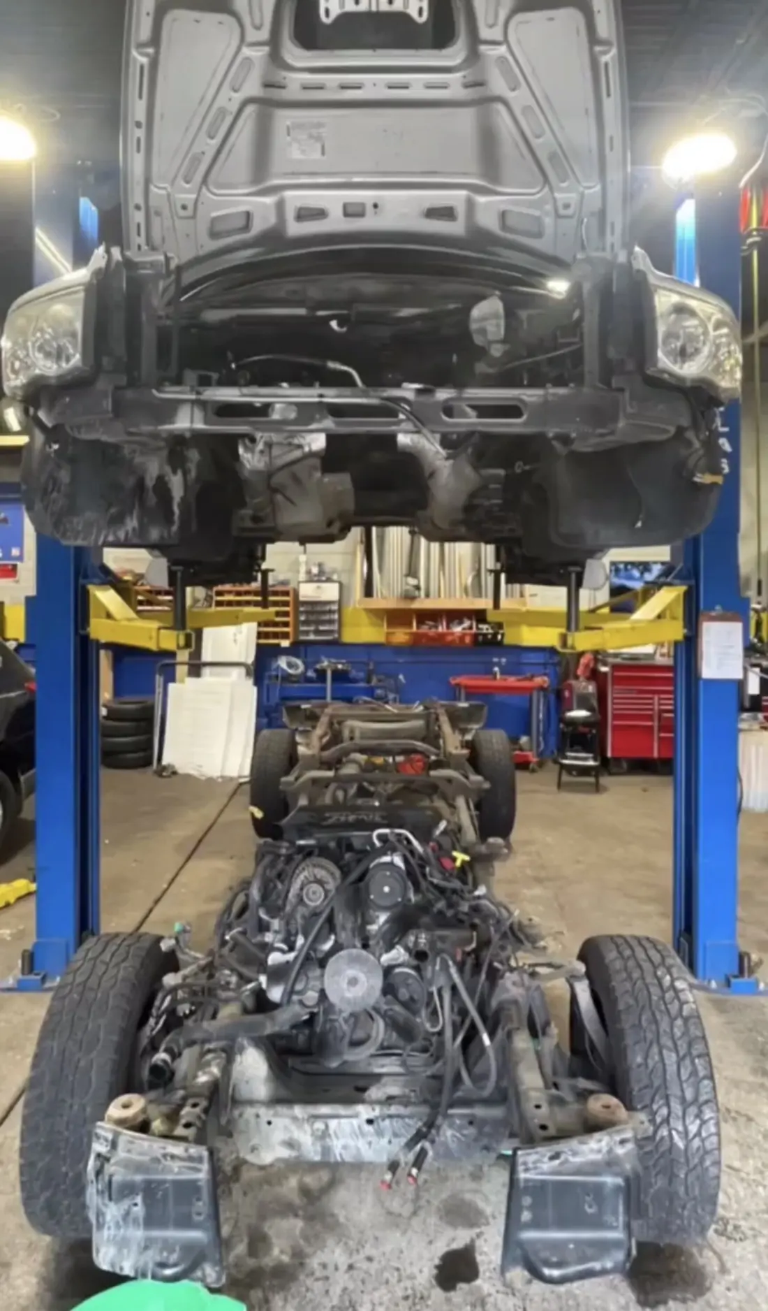 Underside of a vehicle raised on a two-post lift during driveline work