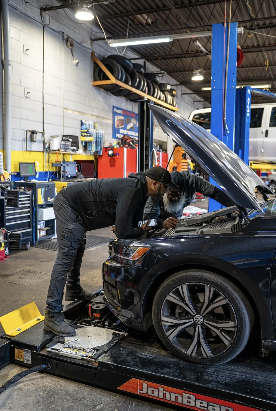 A technician diagnosing a Volkswagen with the hood raised
